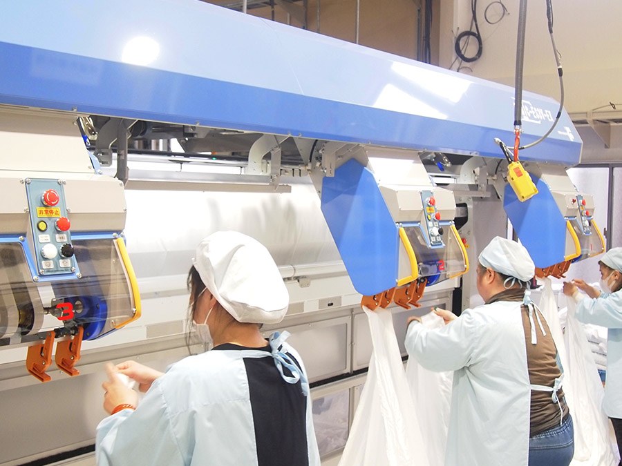 Các công nhân giặt ủi công nghiệp sử dụng máy móc hiện đại để phân loại và xử lý đồ giặt, đảm bảo chất lượng và hiệu suất công việc. giat-ui-cong-nghiep-nhat-3